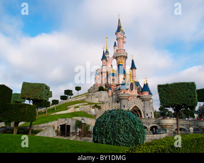 The pink sleeping beauty castle in fantasyland the center of Eurodisney Paris France with cubic trimmed trees Stock Photo
