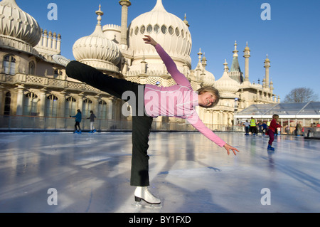 A woman skater on the temporary pop-up ice skating rink in front of the Brighton Royal Pavilion. Stock Photo