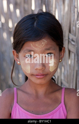 Myanmar, Burma, Mrauk U. Young village girl with her face decorated with thanaka, a local sun cream made from ground bark, Stock Photo