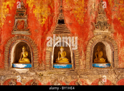 Myanmar, Burma, Nyaungshwe. A trio of small Buddhas set into the temple wall, Shwe Yaunghwe Kyaung monastery, near Inle Lake. Stock Photo