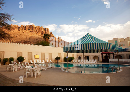 Oman, Nizwa. The pool at the Falaj Jaris Hotel is surrounded by the Jabal Akhdar Mountains. Stock Photo