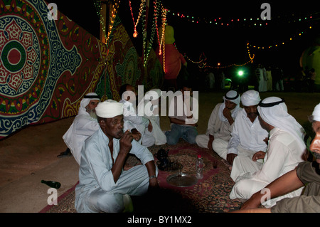 Guests converse over tea during traditional Bedouin wedding celebration. El Tur, Sinai Peninsula, Egypt Stock Photo