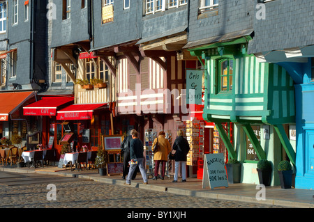 Harbour sided shops with an older couple looking in the window with arms around each other. Honfleur, Normandy, France. Stock Photo