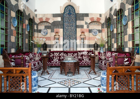 A traditional Syrian outdoor sitting area with Islamic decor and motifs, located in the courtyard of a home in the old quarter of Damascus, Syria. Stock Photo