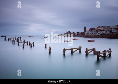 England, Dorset, Swanage.  The timber remains of the Old Pier at Swanage, and the Wellington Clock Tower in the background, Stock Photo