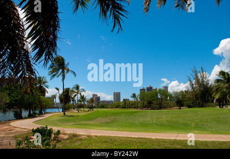 Honolulu Hawaii golfing at local Ala Wai Golf Course with Honolulu city behind in Oahu Stock Photo