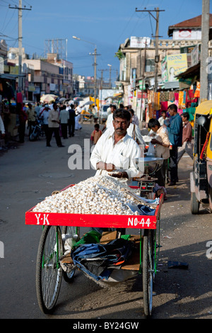 India, Mysore. A man sells garlic in a busy Mysore street. Stock Photo