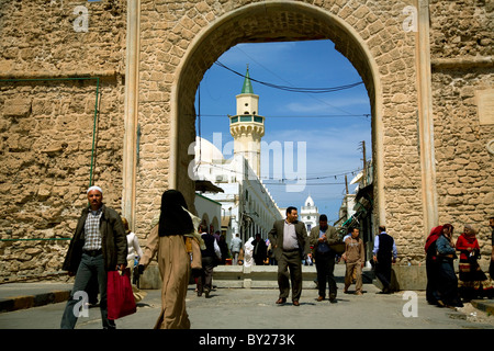 Tripoli, Libya; A man and his wife wearing a 'burka' walking in front of one of the main gates leading to the Old Medina Stock Photo