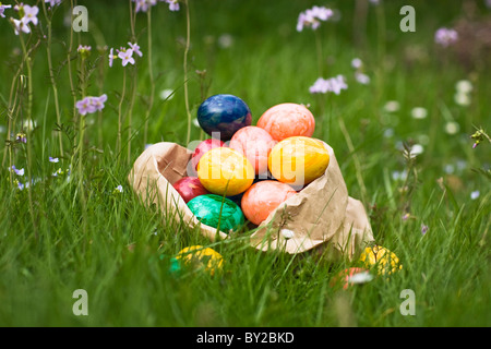 Paper bag full of Easter eggs in grass Stock Photo