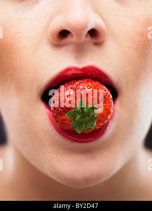 white woman biting on a stawberry