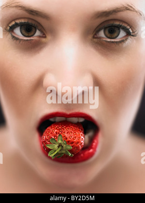 white woman biting on a stawberry