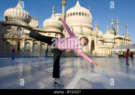 A woman skater on the temporary pop-up ice skating rink in front of the Brighton Royal Pavilion. Stock Photo