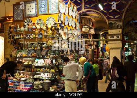 Grand Bazaar Ceramics Shop Istanbul Turkey | ISTANBUL, Turkey — Shelves of hand-painted ceramic plates and vases fill a shop called Star Çini inside Istanbul's Grand Bazaar, their cobalt and red floral patterns echoing the İznik pottery tradition. Founded by Sultan Mehmed II in the mid-15th century, the bazaar remains one of the largest covered markets in the world, and ceramics rank among its most celebrated wares. Stock Photo