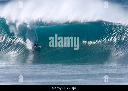 A young man surfs a perfect big barreling wave at the Pipeline, on th enorth shore of Oahu, Hawaii Stock Photo