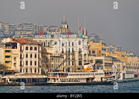 ISTANBUL, Turkey / Türkiye / Türkiye  — A ferry docked in front of the old waterfront of Beyoglu on the Golden Horn in Istanbul, Turkey. The Bosphorus, a vital waterway connecting the Black Sea to the Sea of Marmara, offers stunning scenes of Istanbul with its historic landmarks and bustling maritime activity. This iconic strait divides the city into European and Asian sides, featuring beautiful waterfront palaces, mosques, and bridges. Stock Photo