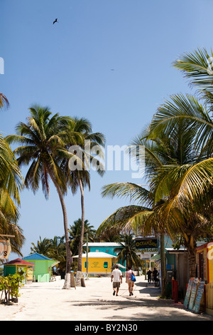 A couple walk down the beach in a small island town in the Caribbean. Stock Photo