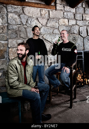 Three men have beers inside the ski lodge Stock Photo