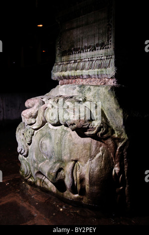 Basilica Cistern Medusa Head Istanbul Turkey | ISTANBUL, Turkey — A carved Medusa head lies on its side as the base of a column in the Basilica Cistern, one of two such reused sculptures in the reservoir's northwest corner. Scholars cannot explain their origin or unusual orientation; the cistern itself dates to the reign of Byzantine Emperor Justinian I in the 6th century. Stock Photo