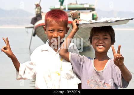 A pair of Burmese kids selling their goods on the banks of the mighty Ayerwaddy River at Pyay in Myanmar. Stock Photo