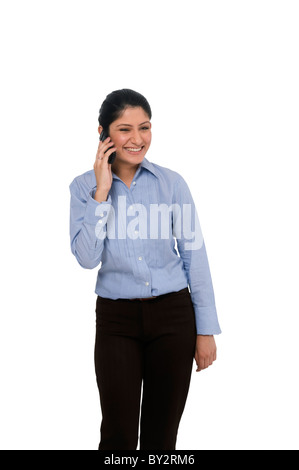 A woman standing and  talking on phone facing the camera Stock Photo