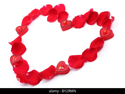 Rose petals and candles forming heart shape on white background. Stock Photo