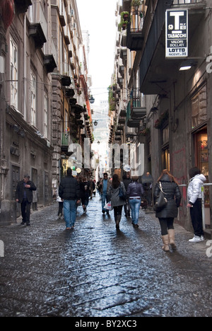 Pedestrians walk along the Spaccanapoli street of Via Benedetto Croce, Naples, Campania, Italy Stock Photo