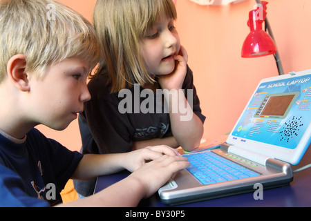 Two children learning from a children's computer Stock Photo