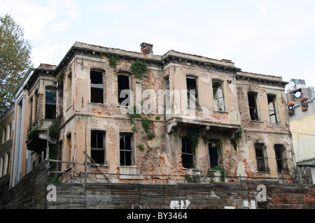 Abandoned Home Cankurtaran District Istanbul Turkey | ISTANBUL, Turkey — A crumbling masonry house, its brick facade overtaken by ivy and its arched windows shattered, stands abandoned in Istanbul's Cankurtaran district near the Blue Mosque. The building reflects a broader pattern of residential decline across the neighborhood, whose permanent population has fallen to roughly a tenth of its early-1960s level as housing converts to tourist accommodation within a UNESCO-protected zone of the historic peninsula. Stock Photo