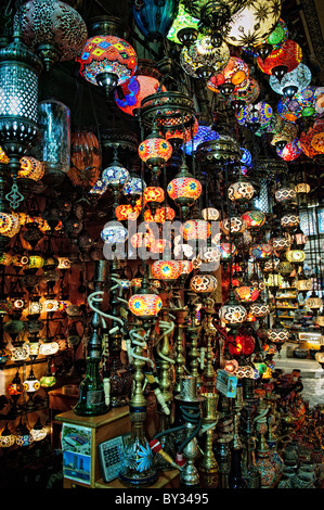 Mosaic Glass Lamps Grand Bazaar Istanbul // ISTANBUL, Turkey — Mosaic glass lamps in vivid colors fill a shop in Istanbul's historic Grand Bazaar, their stained-glass panels and metalwork frames a hallmark of Turkish decorative craft. The hand-assembled fixtures draw on Ottoman design traditions, with each lamp individually constructed from cut glass pieces set into a metal armature. Lamp shops are among the most visually striking in the bazaar, which encompasses some 3,000–4,000 shops along roughly 60 covered streets. Stock Photo