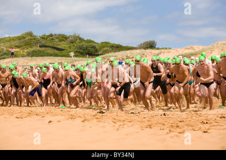 Australia ocean swim race, swimmers sprint from the start line at the start of the Avalon Beach ocean swim race,Sydney,Australia Stock Photo