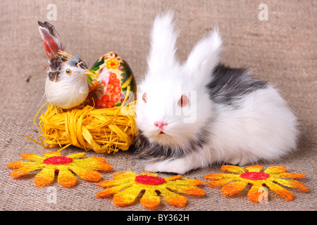 Cute bunny and easter egg in nest on sacking background Stock Photo