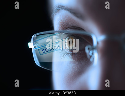 Reflection of search button in businesswoman's glasses Stock Photo