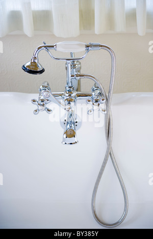 Shower head connected to tap on bath Stock Photo