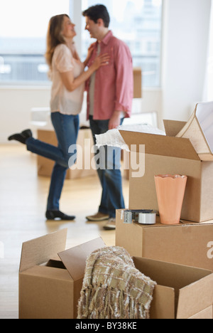 USA, New Jersey, Jersey City, Couple embracing near boxes in new home Stock Photo