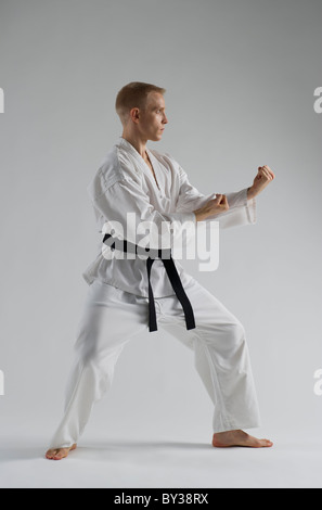 Young man performing karate stance on white background Stock Photo