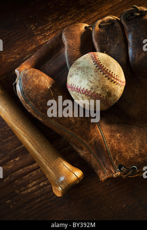 Antique baseball on baseball glove with bat Stock Photo