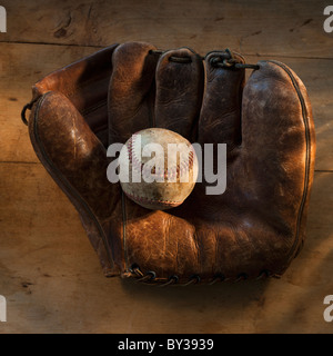 Antique baseball on baseball glove with bat Stock Photo