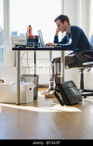 USA, New Jersey, Jersey City, Young man working on laptop in office Stock Photo