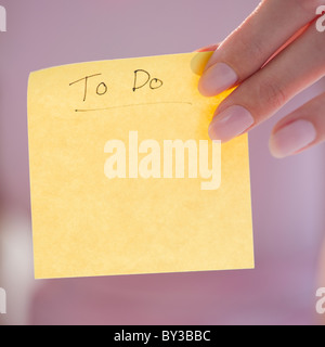 USA, New Jersey, Jersey City, Close-up view of woman hand holding adhesive note for writing down things to do Stock Photo