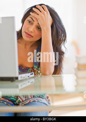 USA, New Jersey, Jersey City, Young Indian woman using laptop Stock Photo