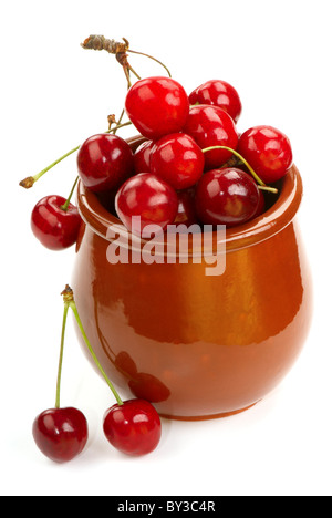 Ripe cherries in a clay pot on a white background. Stock Photo