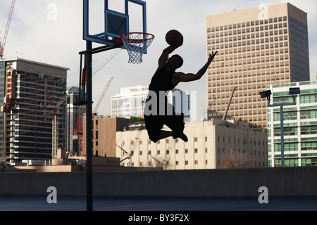 USA, Utah, Salt Lake City, Silhouette of young man playing basketball Stock Photo