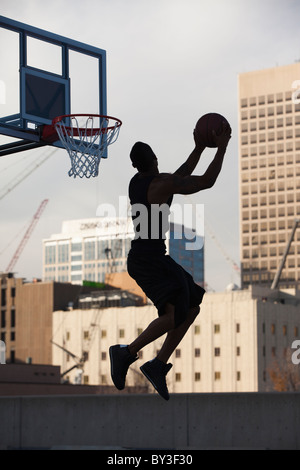 USA, Utah, Salt Lake City, Silhouette of young man playing basketball Stock Photo