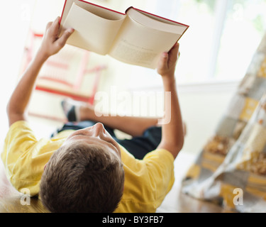 a kid lying on the floor reading a book Stock Photo - Alamy
