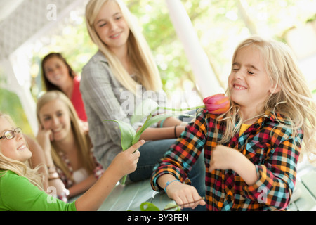 USA, Utah, family portrait of sisters (6-7, 8-9, 12-13, 14-15, 16-17) at table playing with flower Stock Photo