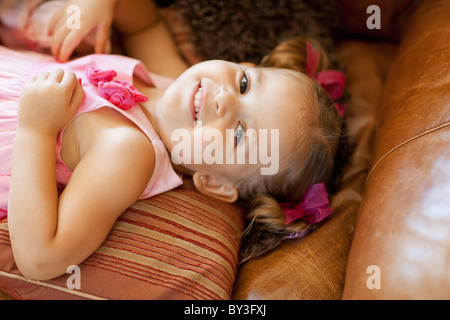 Happy girl lying on sofa, high angle view Stock Photo