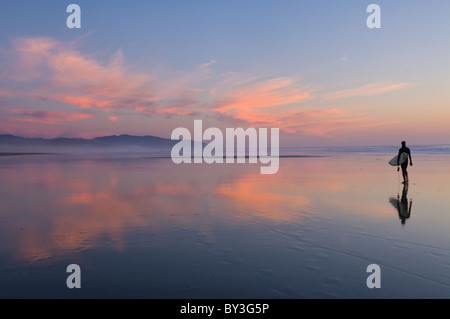 USA, Oregon, lone surfer on beach Stock Photo