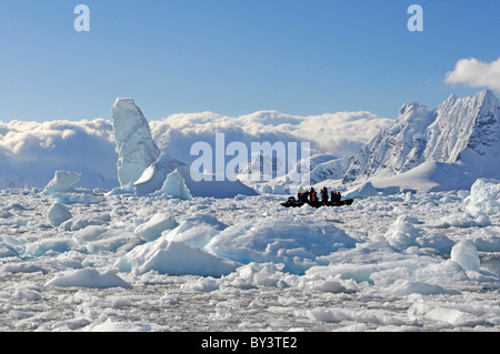 Tourists in a zodiac in front of icebergs in Paradise Bay, Antarctic Peninsula, Antarctica Stock Photo