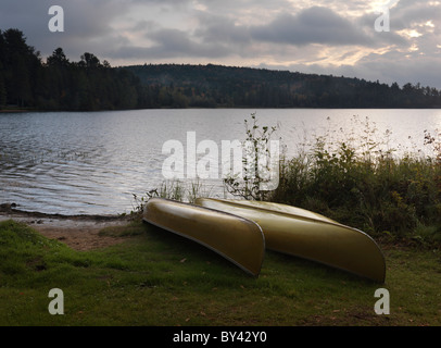 Two canoe on a shore of The Lake of Two Rivers at dawn tranquil fall scenery. Algonquin Provincial Park, Ontario, Canada. Stock Photo