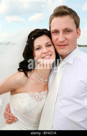 Portrait of handsome groom hugging his beautiful bride Stock Photo